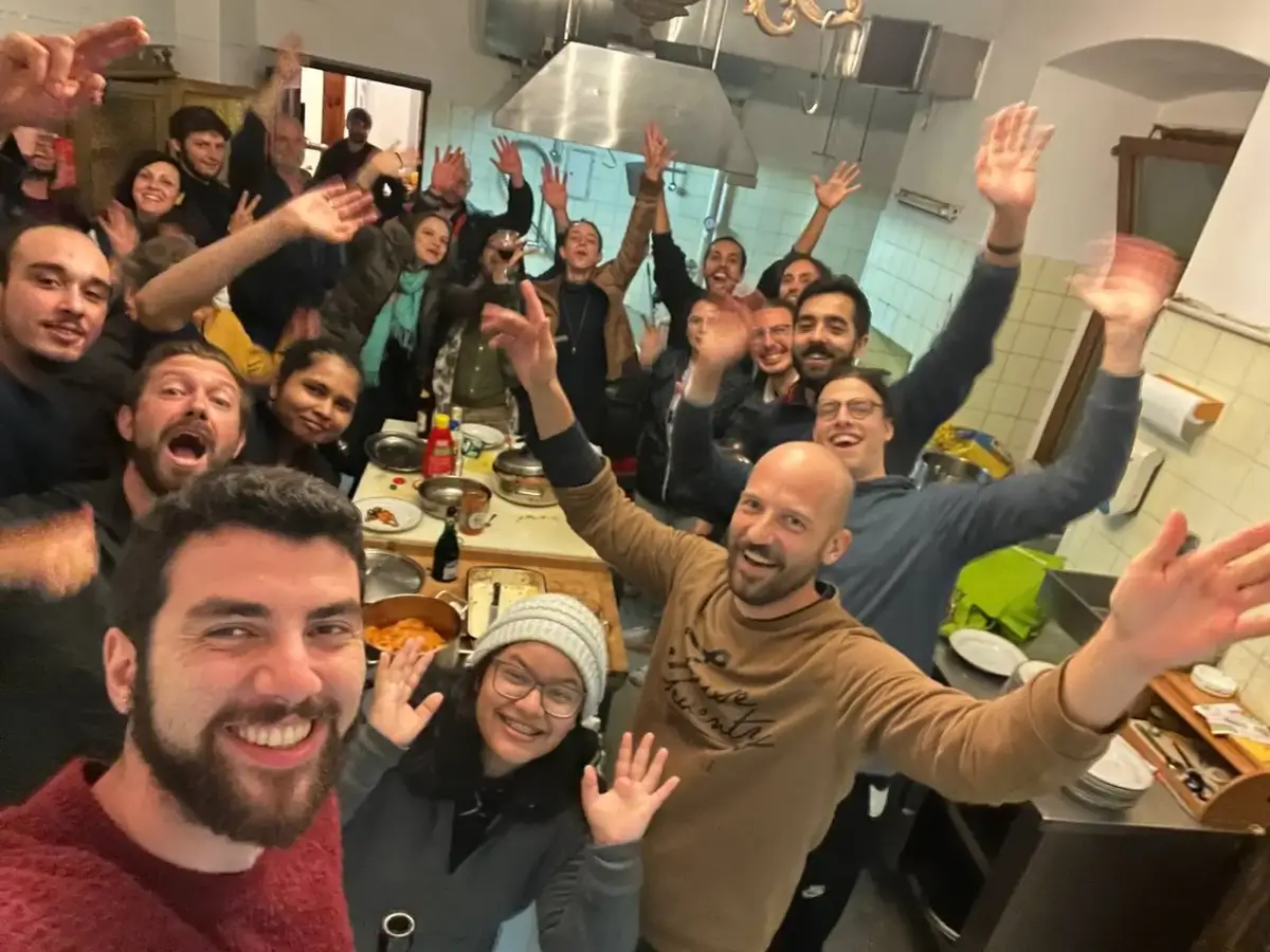 A crowded, cheerful shared dinner in the kitchen